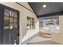 Inviting front porch with a gray door and white picket fence at 3756 Decatur St, Denver, CO 80211