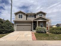 Two-story home with a well-maintained front yard, a two-car garage and neutral-colored siding at 317 Whimsical Ave, Brighton, CO 80603