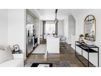 A modern, neutral kitchen flows into the dining area, featuring stainless steel appliances and a granite island with seating at 2862 S Galapago Ct, Englewood, CO 80110