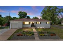 Charming home with landscaped front yard and a walkway leading to the front door at 12017 W 58Th Pl, Arvada, CO 80004