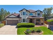 Charming two-story home featuring a manicured lawn and beautiful landscaping at 11513 Greenbriar Ln, Parker, CO 80138