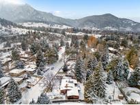 A winter aerial view of a neighborhood nestled in a mountain landscape, capturing the serene beauty of snow-covered homes at 1333 Mariposa Ave, Boulder, CO 80302