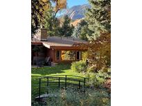 Charming home exterior featuring a lush garden, stone chimney, and a scenic mountain view at 1333 Mariposa Ave, Boulder, CO 80302