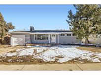 Newly remodeled home with a gray exterior, white door, and attached garage at 1040 Hoover Ave, Fort Lupton, CO 80621