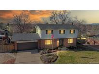 Charming two-story home with brick accents, a well-kept lawn and an American flag at 954 E Costilla Ave, Centennial, CO 80122