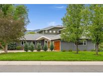 Two story home with lush lawn, mature trees, and mountain views at 831 Crescent Dr, Boulder, CO 80303