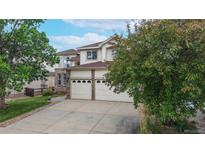Two-story home featuring a three-car garage and manicured landscaping at 7597 Bison Ct, Littleton, CO 80125