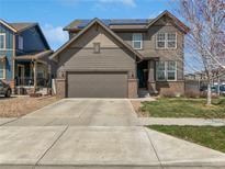 Charming two-story home with a two-car garage, landscaped yard, solar panels and neutral brown siding at 1826 Sunshine Ave, Longmont, CO 80504