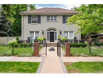 Elegant home showcasing manicured landscaping, black shutters, a tile roof, and a welcoming front entrance at 121 N Marion St, Denver, CO 80218
