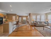 Inviting living room flows into a well-lit dining area and kitchen with a breakfast bar at 11150 Night Heron Dr, Parker, CO 80134