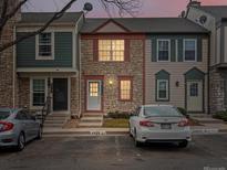 Charming townhouse with a stone facade, red accents, and a well-lit doorway at 2909 W 81St Ave # E, Westminster, CO 80031