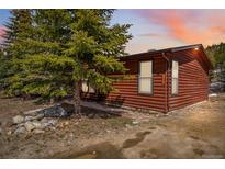 Charming log cabin exterior with mature trees and landscaped surroundings, nestled in a serene, natural setting at 764 Blue Ridge Rd, Breckenridge, CO 80424