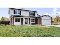 Charming two-story home featuring a well-manicured lawn and inviting front porch at 5199 Arbutus St, Arvada, CO 80002