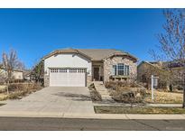 Charming single-story home featuring a stone facade and well-manicured front yard, perfect for curb appeal at 16494 Aliante Dr, Broomfield, CO 80023