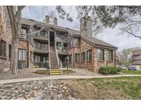 Brick condo building featuring multiple balconies, with stairs leading to the units at 814 S Vance St # F, Lakewood, CO 80226