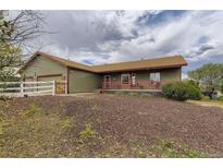 Charming home featuring an inviting porch and a well-manicured front yard at 11549 Haskell Creek Rd, Larkspur, CO 80118