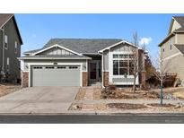 Charming single-Gathering home with stone accents, gray siding, and a well-maintained front yard and driveway at 15271 Grasslands Dr, Parker, CO 80134