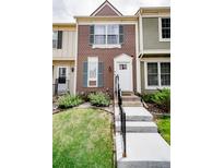 Charming townhouse featuring a well-manicured lawn and inviting entryway with concrete stairs and black railings at 1699 S Trenton St # 69, Denver, CO 80231