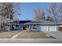 Charming single-story home with light blue siding, an attached garage, and mature trees in the front yard at 3133 S Gaylord St, Englewood, CO 80113