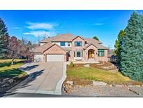 Beautiful brick home featuring a landscaped front yard, circular driveway, and multi-car garage at 9 Mule Deer Trl, Littleton, CO 80127