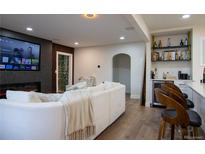 Comfortable living room with fireplace, large screen TV, and bar area with stools and shelves at 3701 S Grant St, Englewood, CO 80113