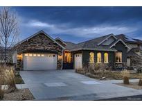 Beautiful home exterior showcases a two-car garage, manicured lawn, and inviting curb appeal at dusk at 9521 Garnett Way, Arvada, CO 80007