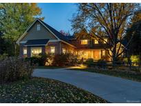 Brick two-story home with a landscaped yard and a long driveway at 5110 S Logan Dr, Greenwood Village, CO 80121
