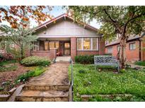Charming brick home featuring manicured lawn, stone walkway and cozy front porch at 730 Cook St, Denver, CO 80206