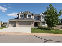 Charming two-story home featuring a three-car garage, well-manicured lawn, and mature tree providing shade at 1881 Alma Ln, Superior, CO 80027