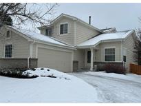 Charming two-story home with attached garage, snow-covered lawn, and inviting entrance at 18336 E Amherst Dr, Aurora, CO 80013