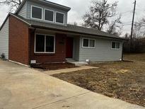 Charming single-story home featuring brick and gray siding, complemented by a well-maintained front yard at 6396 S Hill St, Littleton, CO 80120