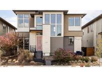 Stylish modern two-story home showcasing unique architectural design and a vibrant pink front door at 9388 E 59Th Pl, Denver, CO 80238