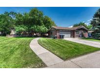 Charming brick home featuring a well-manicured lawn, mature trees, and a welcoming walkway to the front door at 5380 S Prescott St, Littleton, CO 80120