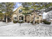 Two-story house with stone accents and a covered porch, snow-covered lawn at 10106 Grove Loop # A, Westminster, CO 80031