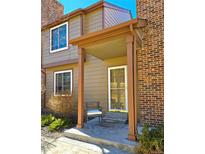 Charming front entrance with a cozy porch, a chair, and a combination of brick and siding at 886 Summer Dr, Highlands Ranch, CO 80126