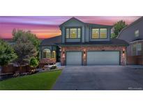 Charming two-story home featuring a well-manicured lawn, stone accents, and a spacious two-car garage at 9772 Clairton Pl, Highlands Ranch, CO 80126