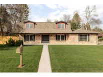 Charming brick home featuring a well-manicured lawn and inviting front entrance at 6211 W Fremont Pl, Littleton, CO 80128