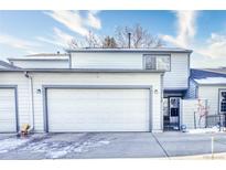 Inviting two-story home showcasing a spacious two car garage, neutral siding, trimmed in gray, and a well manicured front yard at 14120 E Warren Pl, Aurora, CO 80014