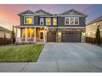 Inviting two-story home with a covered front porch, stone accents, and an attached two-car garage at 1825 Wingfeather Ln, Castle Rock, CO 80108