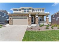 Charming two-story home featuring stone accents, a two-car garage, and a welcoming front porch at 23883 E Minnow Cir, Aurora, CO 80016