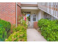 Charming condo entrance with beautiful flower beds and brick accents creating a welcoming appeal at 3040 W Prentice Ave # B, Littleton, CO 80123