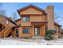 Charming brown two-story home with a brick chimney and covered front porch at 9400 E Iliff E Ave # 43, Denver, CO 80231