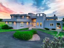 Striking home featuring a modern architectural design, meticulous landscaping, and circular driveway at 7330 Centennial Dr, Parker, CO 80138