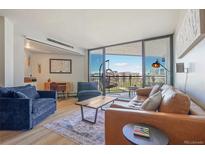 Inviting living room with balcony access offering city views at 550 E 12Th Ave # 810, Denver, CO 80203