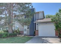 Two-story home with gray siding, brick accents, attached garage, and mature landscaping at 562 W Crestline Cir # 7D, Littleton, CO 80120