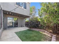 Private backyard featuring artificial turf, patio, mature landscaping and string lights at 1233 S Yosemite Way # 74, Denver, CO 80247