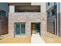 Modern home featuring a brick facade, large windows, and sleek contemporary design at 11487 E Briarwood Cir, Centennial, CO 80112