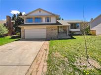 Charming two-story home features a brick facade, attached garage, and well-maintained front yard at 16750 E Ada Pl, Aurora, CO 80017