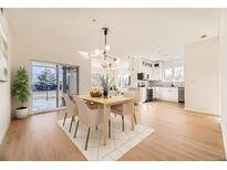 Bright dining area with modern chandelier, adjacent to a sleek, updated kitchen with stainless appliances at 2896 W Riverwalk Cir # A102, Littleton, CO 80123