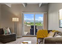 Living room with sliding glass door leading to a balcony and mountain views at 130 N Pearl St # 805, Denver, CO 80203